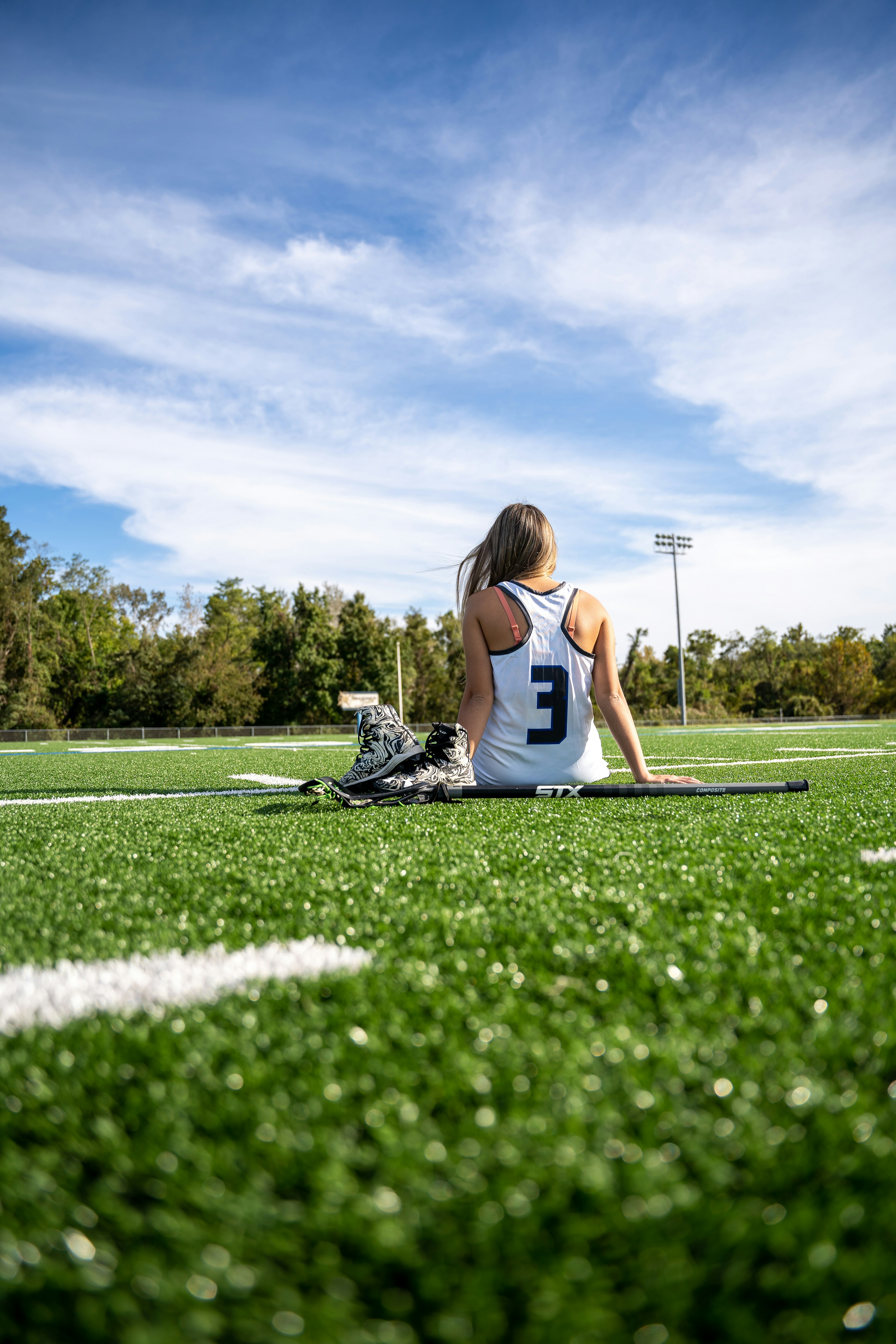 Girls lacrosse player on the field at sunset