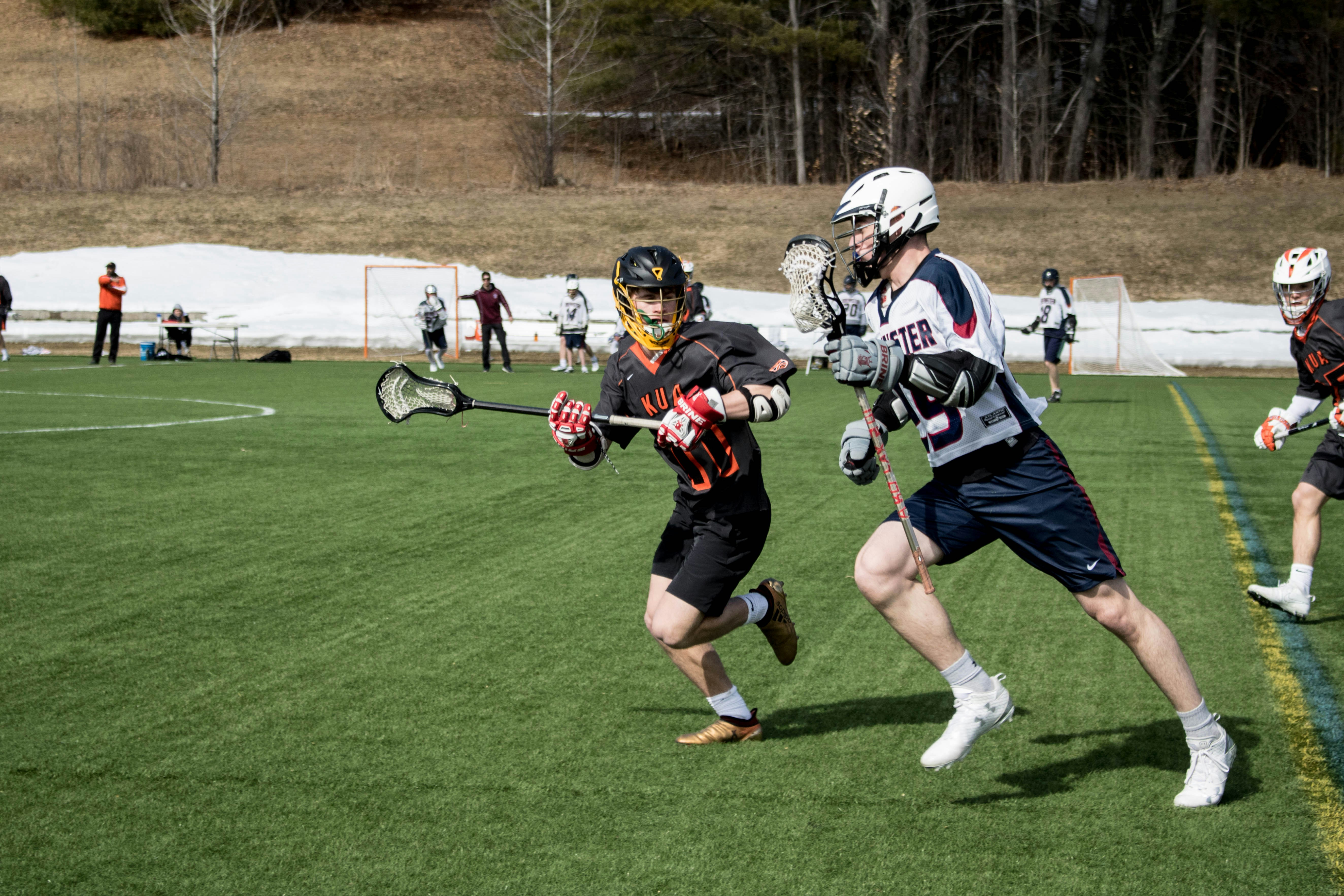 Lacrosse player cradling past a defender