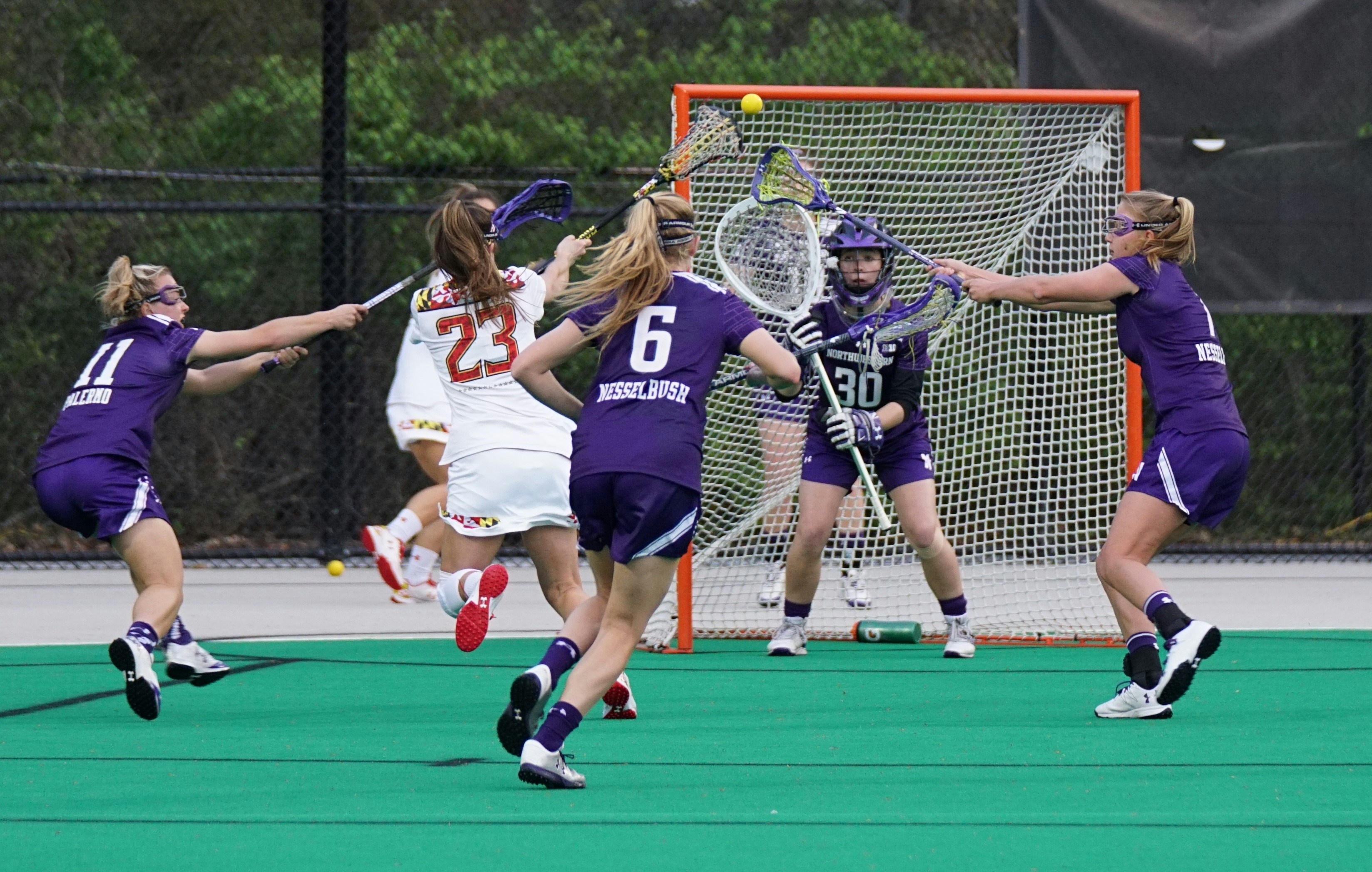 Girls lacrosse player shooting on goal