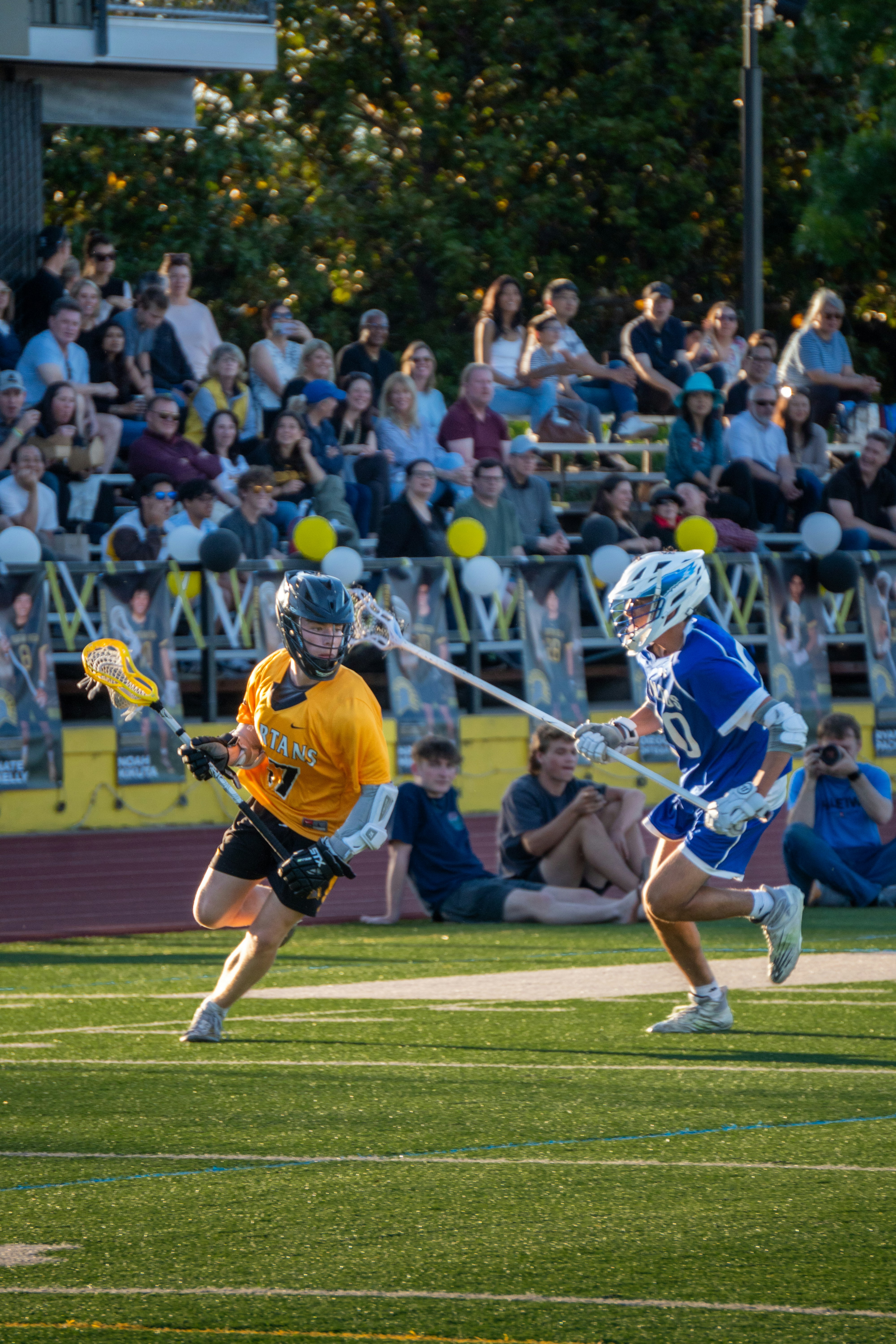 Lacrosse player running with the ball at golden hour
