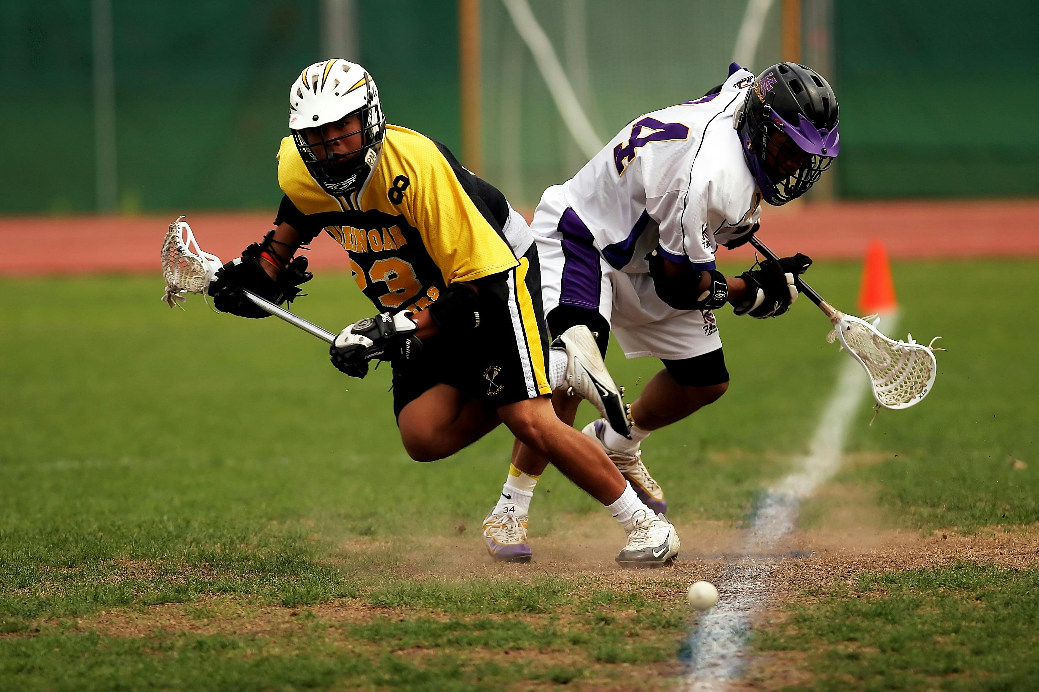 Boys lacrosse players battling for ground ball